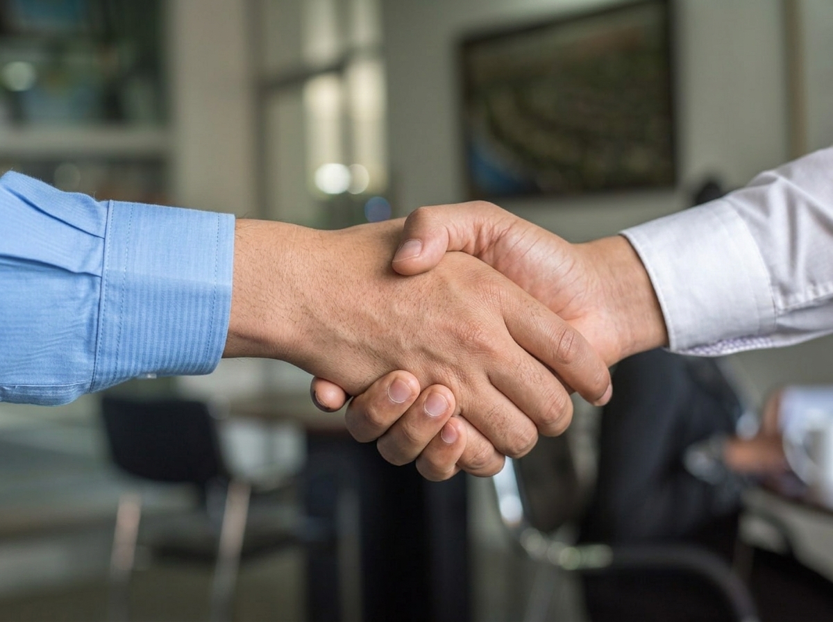 Two professionals shaking hands to begin a partnership